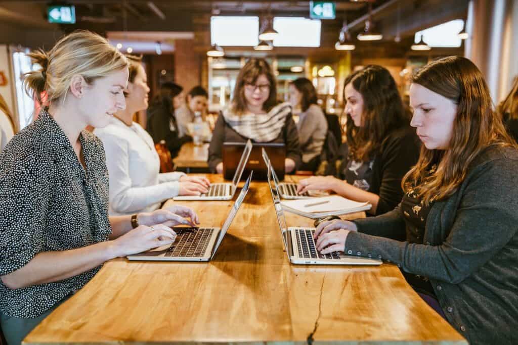 Women teaching other women how to code in a library How to Prepare for Coding Bootcamp