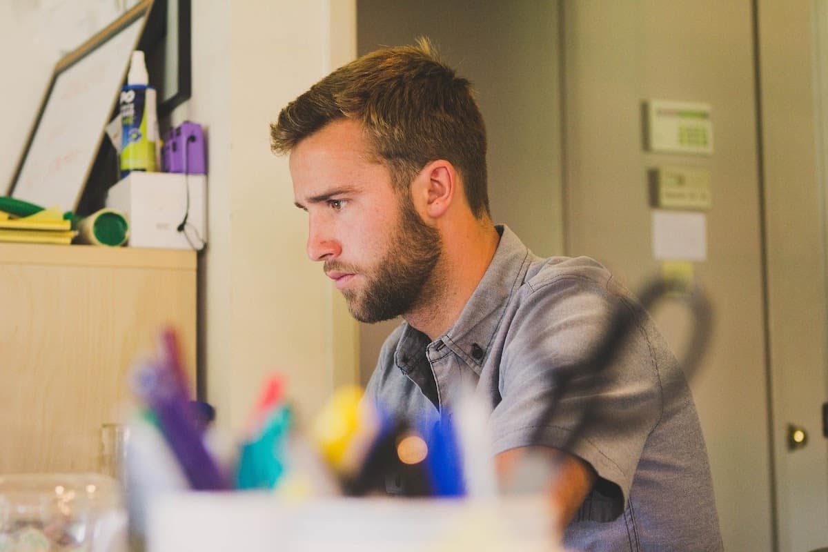 Man pondering Silicon Valley job openings in front of a computer how to get a tech job without a degree