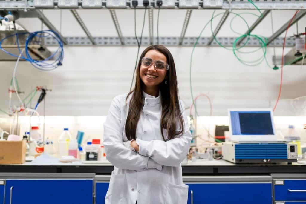 A female scientist wearing protective goggles standing in a lab women in stem careers