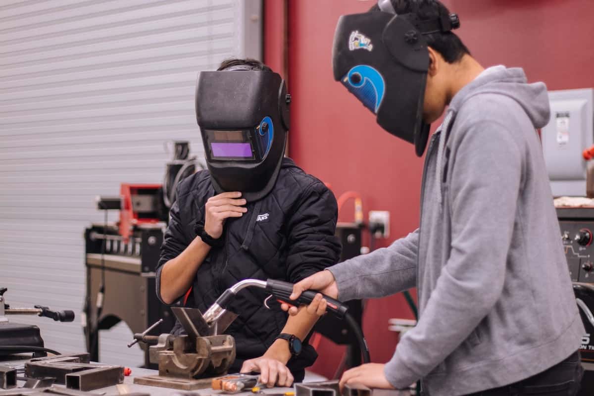 Two people working on a device with masks on. What Is STEM?