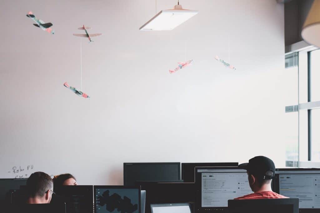 People coding at computers in an office coding bootcamp scholarships