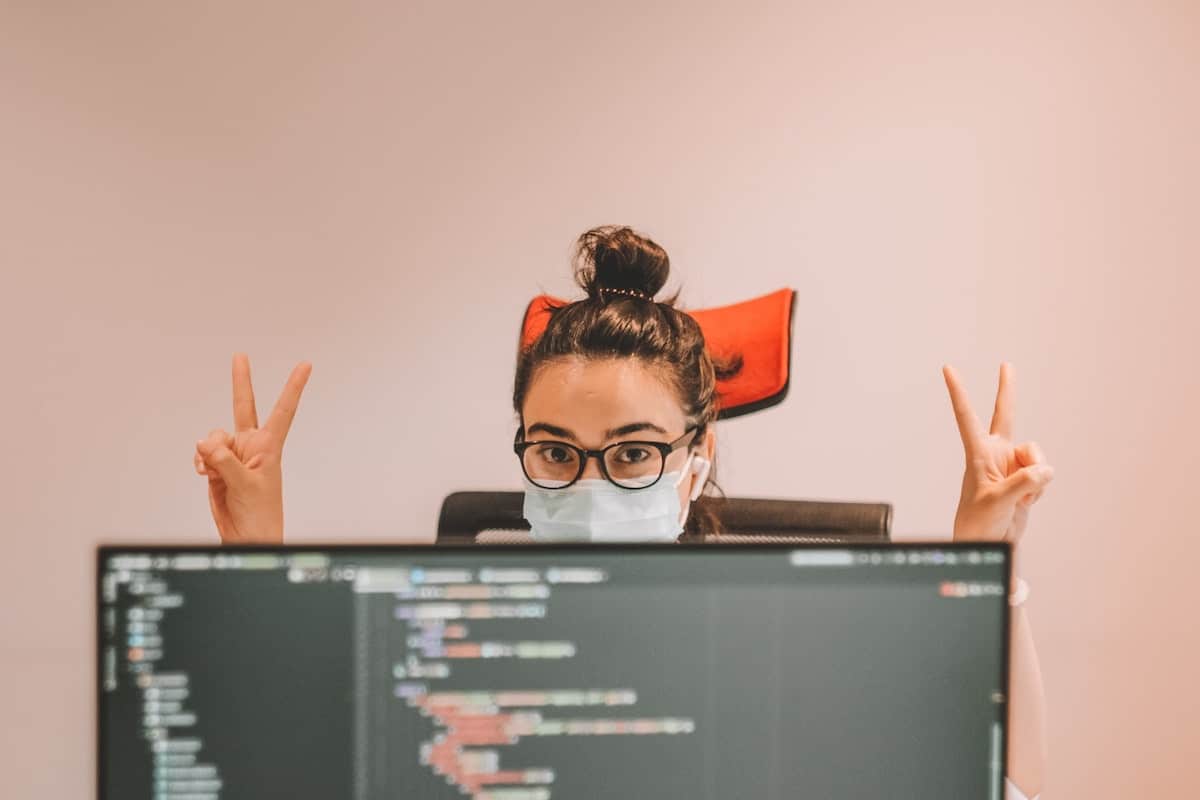 Person in coding bootcamp giving peace signs coding bootcamp scholarships