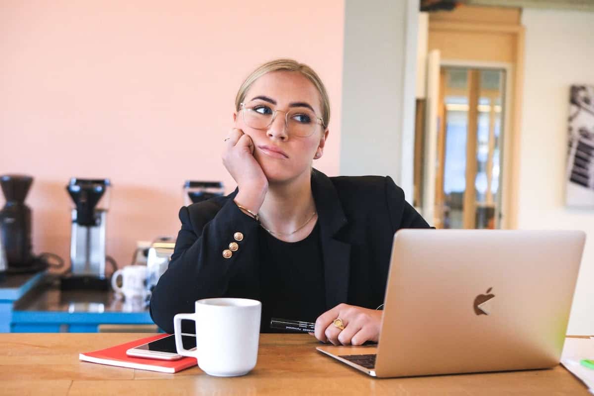 A woman in a black jacket and glasses with a MacBook in front of her is it too late to change careers