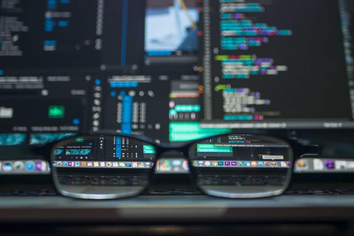 Eyeglasses on top of a laptop in front of a computer screen displaying code. Getting a Job After a Coding Bootcamp