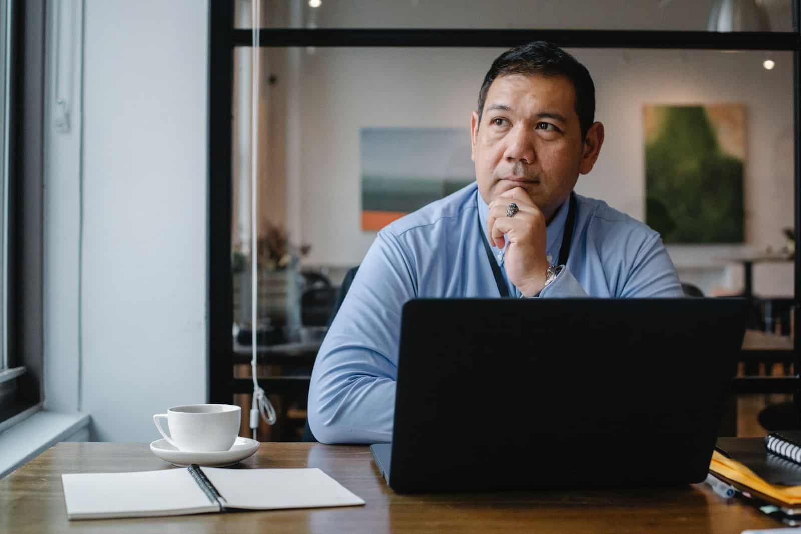 A man with a laptop in front of him staring thoughtfully How to Make a Career Change