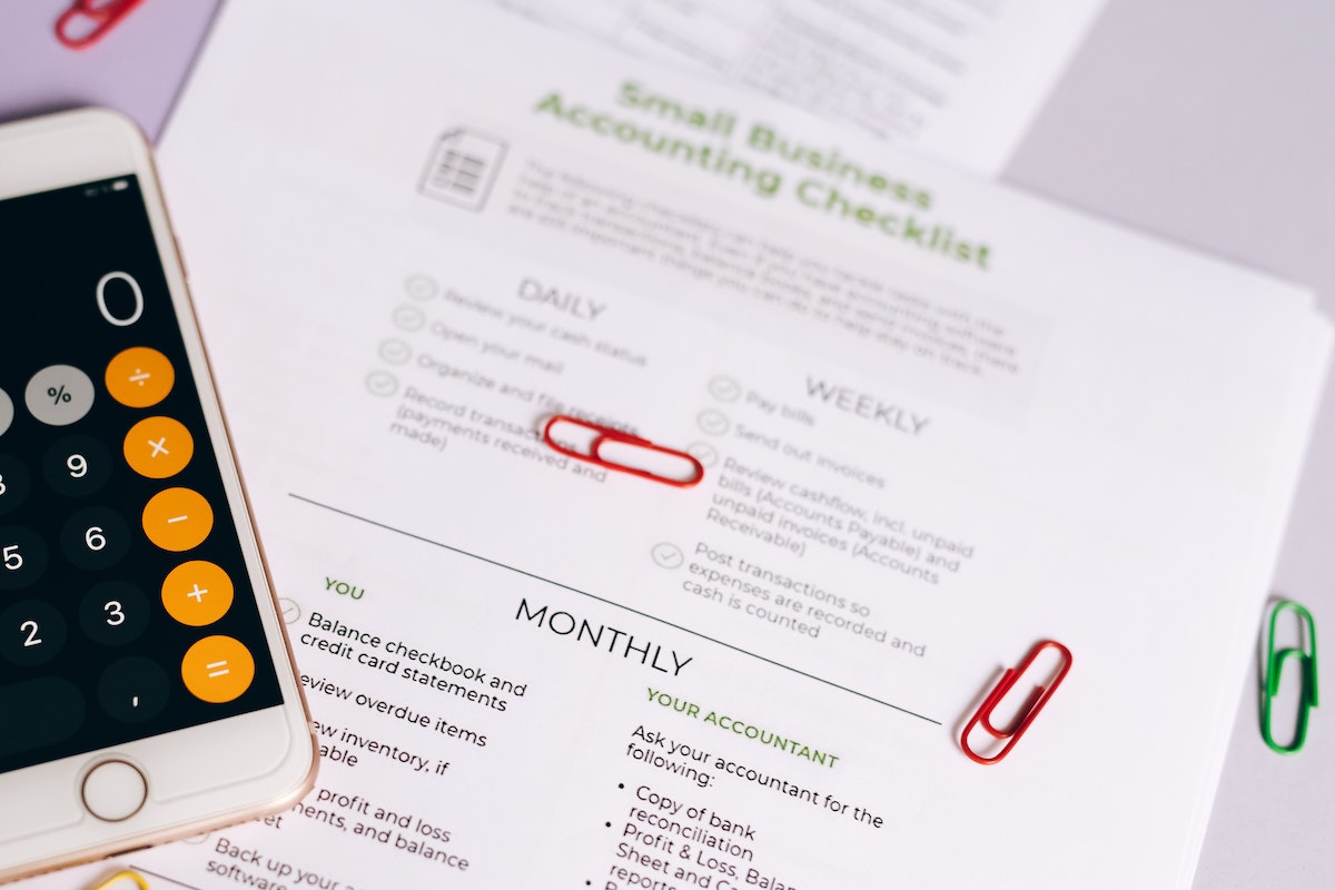 Small business accounting forms and phone calculator scattered on a desk