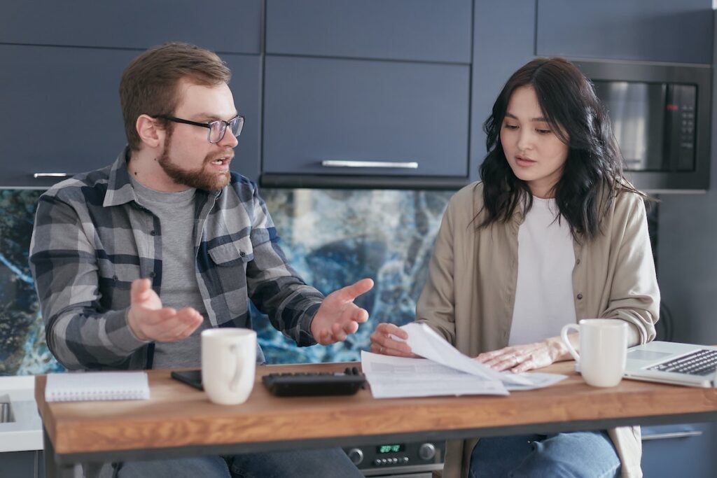 Two accountants sitting at a table discussing business finances.