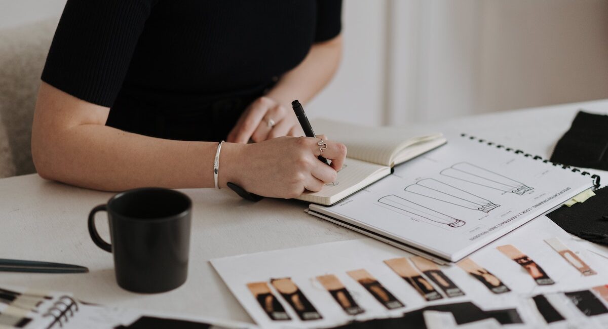A graphic designer drawing sketches in a notebook.