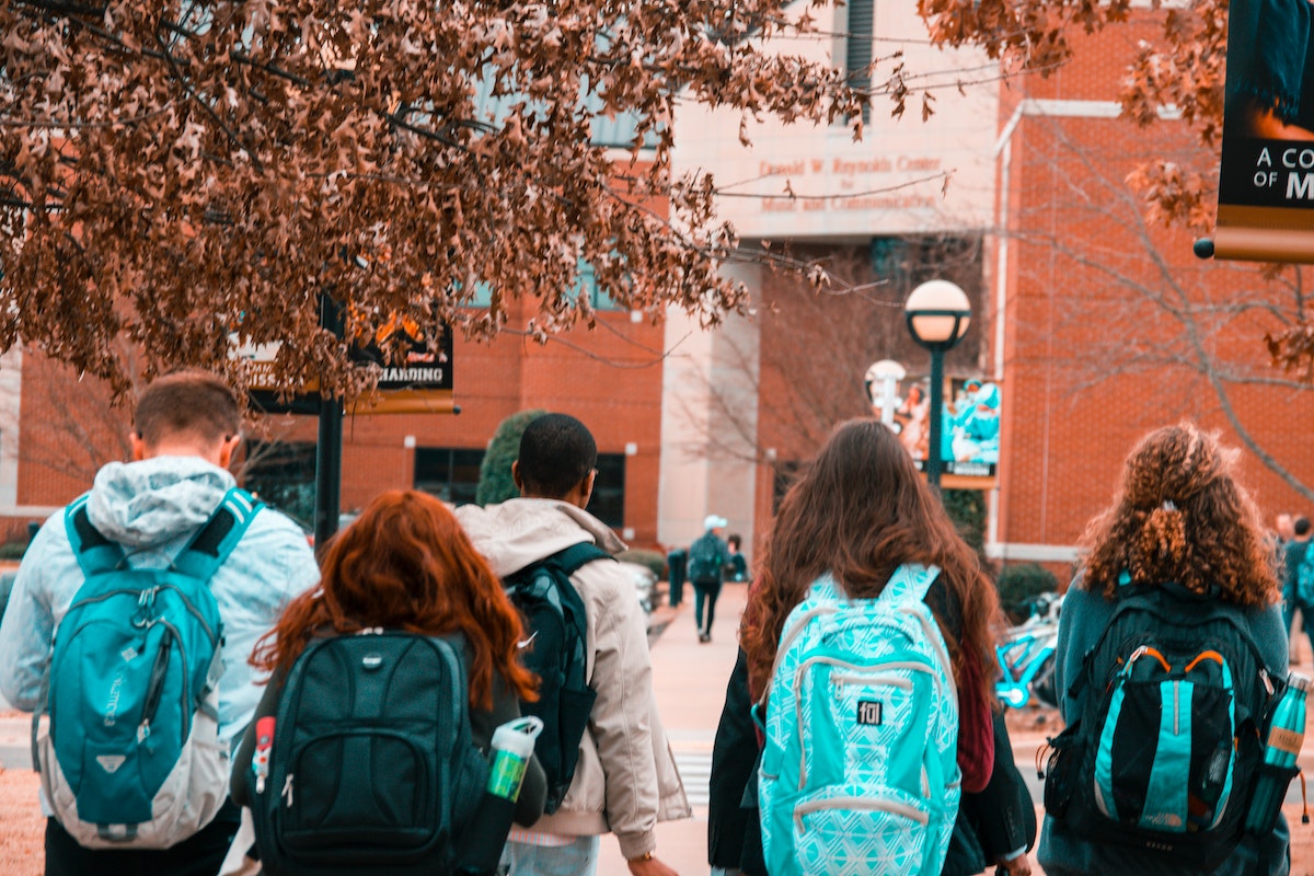 A group of college students turning wearing backpacks.